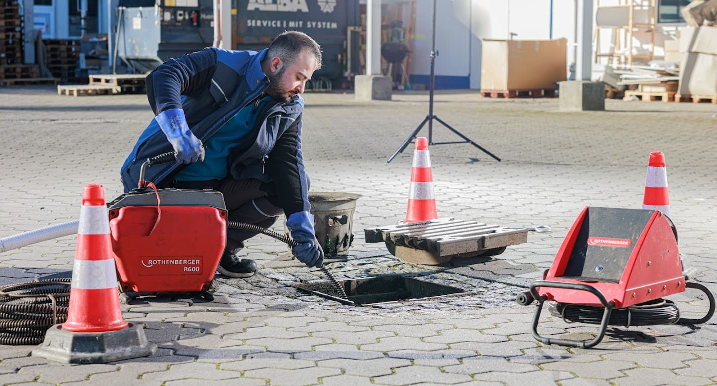Techniker führt Rohrreinigung mit Motorspirale durch